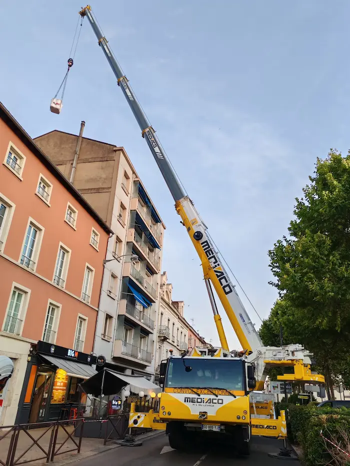 Levage d’équipement télécom par grue à Lyon en journée Grue soulevant un équipement télécom en plein jour à Lyon